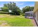 Expansive backyard with lush green grass and a screened-in patio area at 3661 Kingswood Ct, Clermont, FL 34711