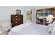A bedroom features a wicker dresser and access to the outdoor screened lanai at 3661 Kingswood Ct, Clermont, FL 34711