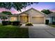 Charming single-story home featuring a well-manicured lawn, mature landscaping and an attached two-car garage at 3661 Kingswood Ct, Clermont, FL 34711