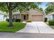 Beautiful single-story home with a well-manicured lawn and a two car garage at 3661 Kingswood Ct, Clermont, FL 34711