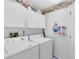 Bright laundry room features white appliances and ample upper cabinet storage at 3661 Kingswood Ct, Clermont, FL 34711