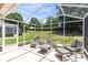 Relaxing screened patio with comfortable lounge seating and a serene backyard view at 3661 Kingswood Ct, Clermont, FL 34711