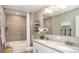 Elegant bathroom featuring double vanity, granite countertop, and tiled shower with modern fixtures at 3880 Bluethread Way, Poinciana, FL 34759