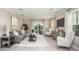 Well-lit living room with neutral decor, tile flooring, and sliding glass doors to the patio at 3880 Bluethread Way, Poinciana, FL 34759