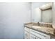 Bathroom featuring granite countertop, white cabinetry, and a well-lit mirror for a clean and functional space at 409 Lake Ned Rd, Winter Haven, FL 33884