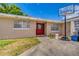Charming single-story home featuring a bright red front door and a basketball hoop on the driveway at 409 Lake Ned Rd, Winter Haven, FL 33884