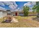 Single-story home with a red door and a neglected lawn, under a cloudy sky at 409 Lake Ned Rd, Winter Haven, FL 33884