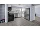 The kitchen has white cabinets, a stainless steel refrigerator, oven and light-colored gray-tile at 409 Lake Ned Rd, Winter Haven, FL 33884