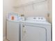 A laundry room with white appliances and a wire shelf at 411 Terrace Ridge Cir # 222, Davenport, FL 33896