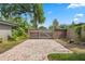 Paved driveway leading to wooden fence and gate, surrounded by lush backyard foliage at 4118 Teriwood Ave, Orlando, FL 32812