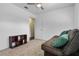 A room with neutral colored walls and carpet, a brown futon, and a view into an adjacent room at 4118 Teriwood Ave, Orlando, FL 32812