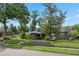 Charming single-story home with manicured landscaping, gray brick wall and mature trees at 4118 Teriwood Ave, Orlando, FL 32812