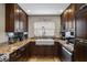 Close-up of the kitchen area featuring granite countertops, dark wood cabinets, and a farmhouse sink at 4118 Teriwood Ave, Orlando, FL 32812