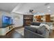 Living room features an entertainment center, brick fireplace, ceiling fan, and open flow to the kitchen at 4118 Teriwood Ave, Orlando, FL 32812