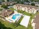 Aerial view of a condo complex showcasing a swimming pool, clubhouse, beach volleyball and landscaped grounds at 422 Terrace Ridge Cir # 422, Davenport, FL 33896