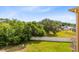 Backyard featuring a green lawn, trees, white fence, and view of nearby houses at 422 Terrace Ridge Cir # 422, Davenport, FL 33896