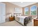 Relaxing bedroom with two windows, neutral walls and floors, and decorative wrought iron bed frame at 422 Terrace Ridge Cir # 422, Davenport, FL 33896