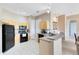 Well-lit kitchen with modern appliances, light wood cabinets, and an adjacent breakfast bar at 422 Terrace Ridge Cir # 422, Davenport, FL 33896