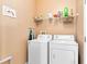 Laundry room features a washer, dryer, shelving, and an ironing board at 422 Terrace Ridge Cir # 422, Davenport, FL 33896