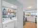 Bright laundry area features front loading washer and dryer and open shelving in this modern condo at 4601 S Atlantic Ave # 7030, Port Orange, FL 32127