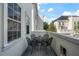 Inviting balcony with an outdoor table and chairs, offering a view of the nearby buildings and trees at 4725 Anson Ln, Orlando, FL 32814