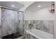 Beautiful bathroom featuring a glass enclosed shower with black honeycomb flooring and a white soaking tub at 4725 Anson Ln, Orlando, FL 32814