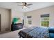 Comfortable bedroom with a ceiling fan, large dresser with TV, and two windows overlooking the exterior at 4725 Anson Ln, Orlando, FL 32814
