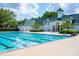 Large community pool offering lap swimming with well maintained deck and attractive clubhouse in the background at 4725 Anson Ln, Orlando, FL 32814