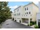 Exterior view of townhomes with attached garages, beige stucco and well-maintained landscaping at 4725 Anson Ln, Orlando, FL 32814
