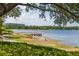 Expansive lake view featuring a wooden pier with a gazebo, surrounded by lush greenery and trees at 4725 Anson Ln, Orlando, FL 32814