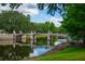 Scenic view of a lake with a charming pedestrian bridge in a beautiful park setting at 4725 Anson Ln, Orlando, FL 32814