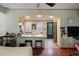 Open-concept living room and kitchen with hardwood floors and arched entryway with bar seating at 4725 Anson Ln, Orlando, FL 32814