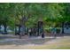A fun community playground with swings, slides, and climbing structures under the shade of mature trees at 4725 Anson Ln, Orlando, FL 32814