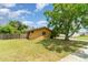 A view of the expansive side yard that shows green grass, a fence and mature trees at 5001 Tangerine Ave, Winter Park, FL 32792