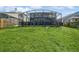 Expansive backyard featuring lush green grass, a dark screened in pool and mature trees at 502 Freeman St, Longwood, FL 32750