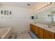 Bathroom featuring double sinks, a large mirror, a soaking tub, and tile floors at 502 Freeman St, Longwood, FL 32750