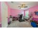 Bright pink bedroom with a ceiling fan, desk, and ample natural light from the window at 502 Freeman St, Longwood, FL 32750