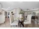 Open concept dining area with a glass table and white chairs adjacent to a modern kitchen and cozy living room at 507 Peach Tree Ln, Altamonte Springs, FL 32701