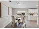 Cozy dining room with a glass table, white chairs, and artwork, complemented by a bright kitchen view at 507 Peach Tree Ln, Altamonte Springs, FL 32701