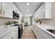 Stylish kitchen boasting white cabinets, gold accents, stainless appliances, and a view into the dining area at 507 Peach Tree Ln, Altamonte Springs, FL 32701