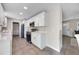 Modern kitchen with white cabinetry, gold hardware, and stainless steel appliances with a view to the living space at 507 Peach Tree Ln, Altamonte Springs, FL 32701