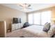Comfortable bedroom featuring a ceiling fan, large window, and a dresser with a television at 525 Narrow View Ln, Groveland, FL 34736