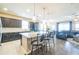 Bright, open kitchen flows into the living area, featuring an island with barstools and dark cabinets at 525 Narrow View Ln, Groveland, FL 34736