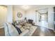 Cozy living room with comfortable seating, a decorative mirror, and hardwood floors at 525 Narrow View Ln, Groveland, FL 34736