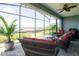 Relaxing screened patio with comfortable wicker furniture and a view of the lush backyard at 525 Narrow View Ln, Groveland, FL 34736