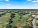 Scenic aerial view of a sprawling golf course surrounded by residential homes, under a clear blue sky at 6330 Masters Blvd # N4, Orlando, FL 32819