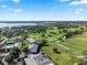 Expansive aerial view of golf course community with lush greens and lake views on a sunny day at 6330 Masters Blvd # N4, Orlando, FL 32819
