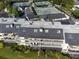 Aerial view of condos featuring screened patios, lush green spaces, tennis courts, and well-maintained landscaping at 6330 Masters Blvd # N4, Orlando, FL 32819