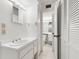 A bright bathroom with white cabinetry, tile floors, and a shower at 6330 Masters Blvd # N4, Orlando, FL 32819