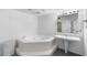 A bright bathroom features a large soaking tub and a pedestal sink at 6330 Masters Blvd # N4, Orlando, FL 32819
